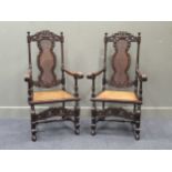 A pair of Charles II style carved walnut bergere armchairs with coronet cresting and acanthus leaf