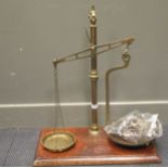 Two early 20th century brass sets of scales on mahogany plinths, largest 72cm high