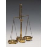 A set of brass balance scales with cylindrical weights, a copper and brass extinguisher, another