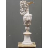 A carved alabaster urn with fruiting vine and bird handle 63cm high and the base of another