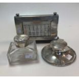 A capstan style silver inkwell and a silver topped glass inkwell, together with a silver fronted