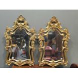 A pair of gilt framed wall mirrors, 20th century, of shaped arch form with C and S scroll decoration