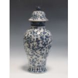 A modern blue and white baluster vase and cover with floral decoration together with a pottery