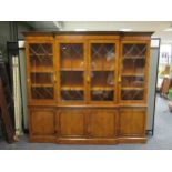 A reproduction burr elm or pollard oak breakfront bookcase the moulded cornice above a glazed