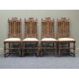 A set of four Victorian caved oak high back dining chairs with barley twist supports and fruit and