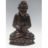 A modern carved hardwood figure of the Buddha seated in prayer, 28 cm high, and a painted ebonised