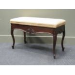 Circa 1900 a mahogany duet stool, the hinged seat over a cabriole legs base with carved decoration