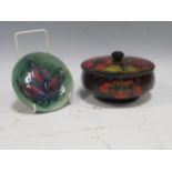 A Moorcroft flambé glazed powder bowl and cover together with a Moorcroft dish