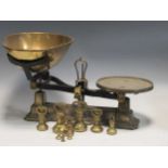 A set of cast iron kitchen scales with a detachable shaped brass pan and a set of brass baluster