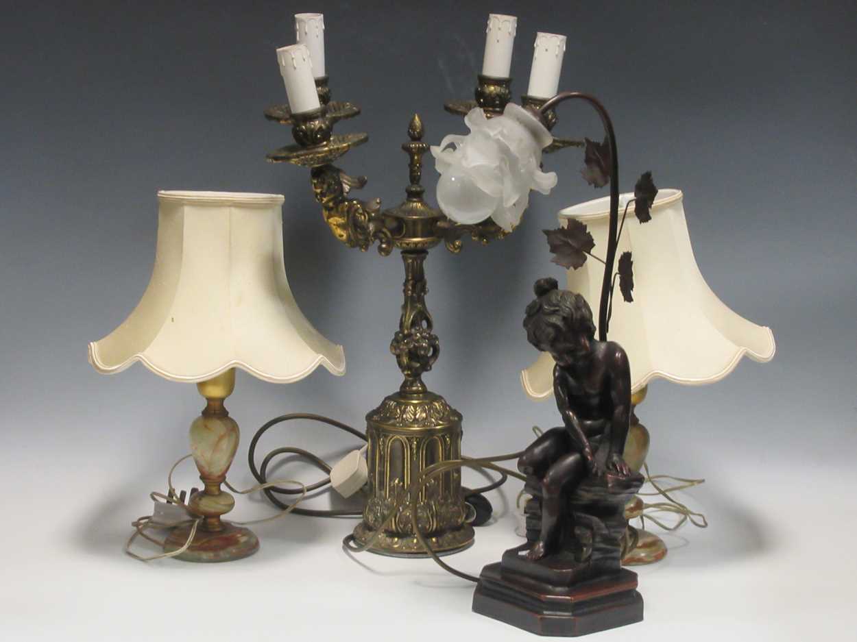 A modern gilt metal four branch table light, two other onyx-based lamps and a modern figural lamp