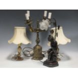 A modern gilt metal four branch table light, two other onyx-based lamps and a modern figural lamp