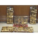 A collection of oriental carved wood and gilt wall panels with traditional designs of figures within
