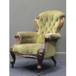 A Victorian carved walnut button back armchair with green upoholstery