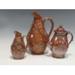 Three 19th century stoneware jugs with raised surface decoration, largest 35cm high