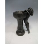After Tom Greenshields, a bronzed sculpture of a girl reaching into a birdbath, indistinctly