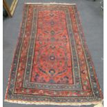 A North West Persian rug with foliate designs on a salmon pink ground, 197 x 113cm