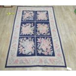 A needle point floor covering decorated with six blue ground floral decorated panels, 264 x 166cm