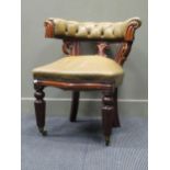 A Victorian hoop back leather button upholstered desk chair raised on turned and reeded front legs