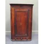 A Georgian oak and mahogany corner cupboard 126cm high and 79cm wide