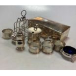 A collection of silver including a mustard pot, a three-piece condiment set, a toast rack, 5