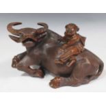 An Asian carved hardwood water buffalo with rider, circa 1900