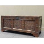 A 17th century and later three panelled oak coffer with carved decoration on later bracket feet 58 x