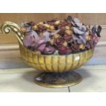 A large carved gilt wood bowl with scroll handle and gadrooned decoration on a circular leaf