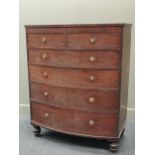 An early 19th century tall mahogany bow front chest of two short and four long graduating drawers