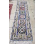 A modern pale ground runner decorated with repeating floral medallions, 320 x 80cm