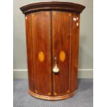 An early 19th century mahogany and inlaid bowfront corner cupboard, 98 x 68 x 48cm