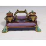 Majolica inkstand with lidded ink wells decorated with rams head and swag relief on scrolled shell