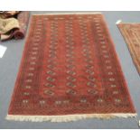 A Tekke style red ground rug 198 x 127cm