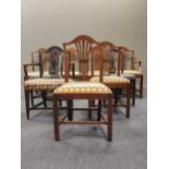 Nine George III style arched back dining chairs with later covered seats