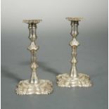 A pair of George II cast silver tapersticks,