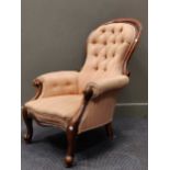 A Victorian walnut spoonback armchair upholstered in pink button back fabric