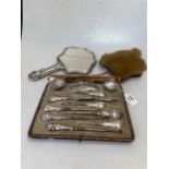 Two incomplete manicure sets with silver handles, together with a silver backed Art Nouveau hand