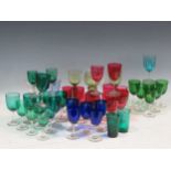 A collection of coloured glassware including highball style glasses and wine glasses