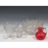 A massive cut glass Punch bowl, A similar smaller pedastal bowl. A ruby glass jug and sundry