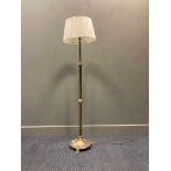 A brass standard lamp with lion paw feet, 140cm high