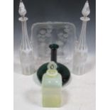 A pair of white overlay glass decanters and stoppers, a green glass ship's decanter, an opalescent