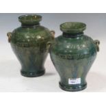 Pair of two handled green glazed vases decorated in an oriental style, 20cm high
