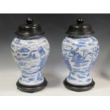 A pair of blue and white Chinese vases with wooden lids and stands, 48cm high