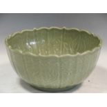 A Chinese celedon green glazed bowl decorated with shallow incised relief, 14cm high and 29cm