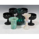 A set of four pressed matte black wine goblets decorated with grapes and vines, together with an