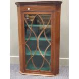 An Edwardian mahogany and strung hanging corner cabinet with intricate glazed single door, 107 x