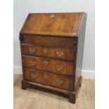 An 18th century and later inlaid walnut bureau, the fall front enclosing a central cupboard with