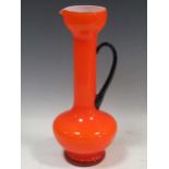 A 1960s orange glass jug with balck glass handle, 32cm high