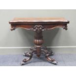 A Victorian rosewood card table, the fold-over serpentine top above a tapered and carved column