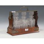 An Edwardian Betjemann's patent Tantalus with three cut glass decnaters in burr walnut frame, with