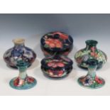 Two Moorcroft powder boxes and covers, a pair of Moorcroft dwarf candlesticks and two small vases (